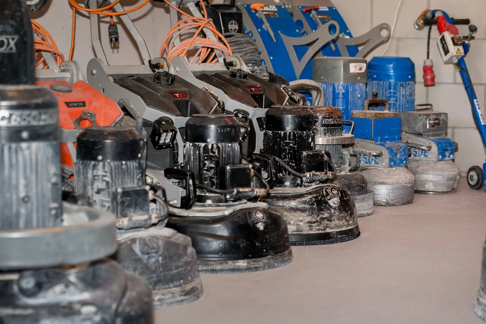 Verschillende industriële vloerbewerkingsmachines, waaronder schuur- en polijstmachines, opgesteld in een werkruimte